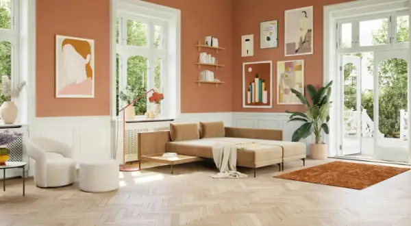 Ein Wohnzimmer mit orangefarbenen Wänden. Ein beiger Teppich und ein Sofa, welche farbe passt zu orange? Weiß und Beige harmonieren perfekt.