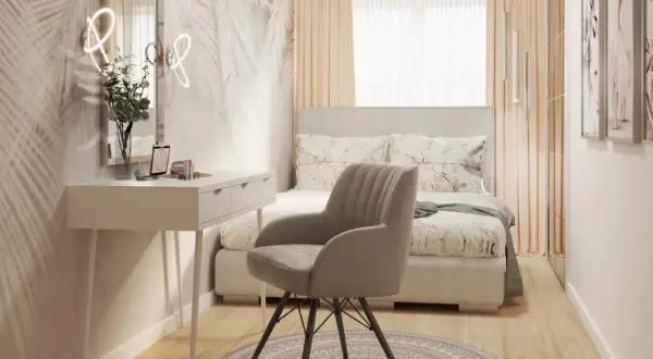 Przytulne łóżko w sypialni pod oknem, z toaletką i wygodnym fotelem.