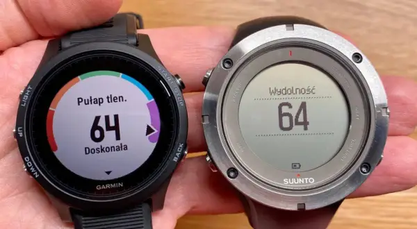 Porównanie zegarków sportowych: Garmin z kolorowym ekranem i pomiarem pułapu tlenowego oraz Suunto z monochromatycznym wyświetlaczem i wskaźnikiem wydolności.