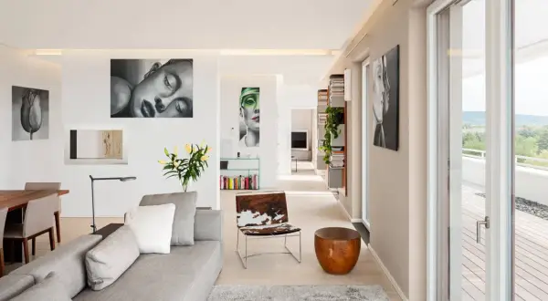 Ein heller Wohnraum mit Kunstwerken, wie sieht die Farbe Beige aus, die Wände und der Boden sind in diesem warmen Ton gehalten.