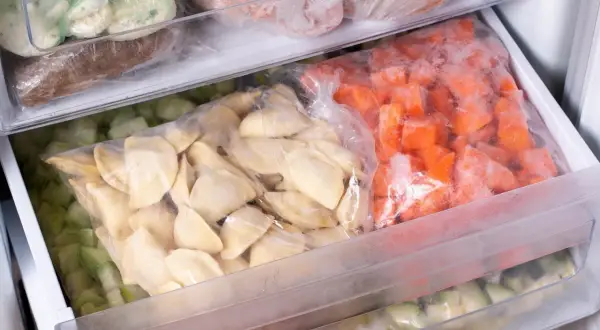 Zamrożone pierogi, marchewka i inne warzywa w szufladach zamrażarki. Zastanawiasz się, ile mogą leżeć pierogi w zamrażarce?