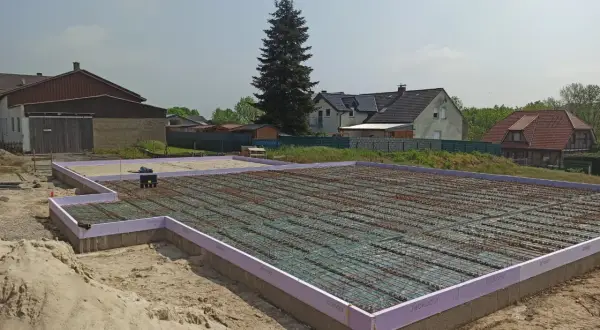 Fundament pod dom w Niemczech, gotowy do zalania betonem. Praca na budowlance trwa.