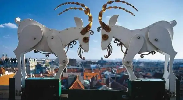 Mechaniczne koziołki poznańskie, bohaterowie legendy, na tle miasta.