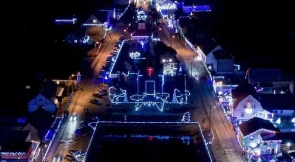 Nocne Popowo rozświetlone tysiącami światełek. Kościół i domy ozdobione świątecznymi iluminacjami tworzą magiczny widok.