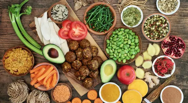 Variedad de alimentos saludables, algunos considerados **reflujo alimentos prohibidos**, como tomates y aguacate, junto a legumbres, verduras y especias.