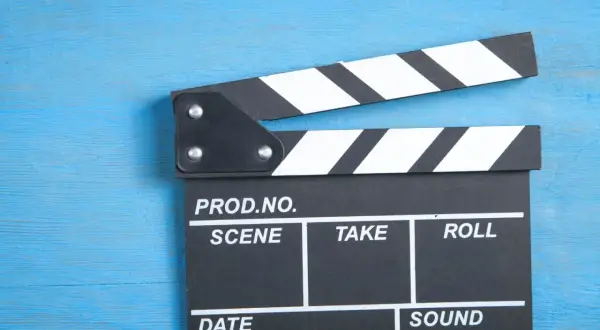 Klapka filmowa na niebieskim tle. Czy zastanawiałeś się, ile zarabia polski aktor?