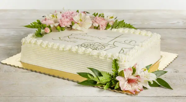 Eleganckie torty na komunie ozdobione kwiatami i symbolem hostii.
