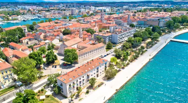 Zadar we wrześniu: słoneczna pogoda, turkusowe morze i urokliwe miasto z czerwonymi dachami. Idealne miejsce na wakacje.