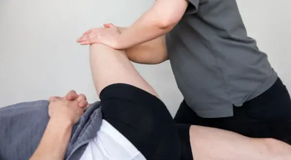 En person får massage på ett ben för att lindra ont i rumpan.