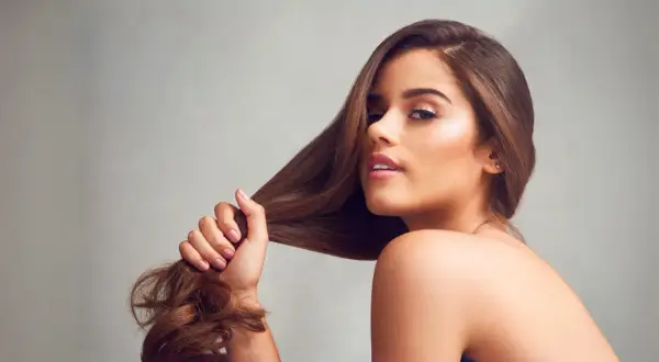 Mujer con cabello largo y sedoso, demostrando el resultado de un excelente cuidado del cabello.