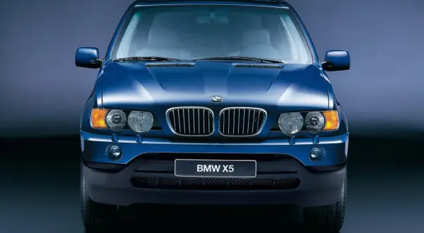 Niebieski BMW X5, pierwszy SUV tej marki, znany z wiki. Klasyczna krata i okrągłe reflektory.