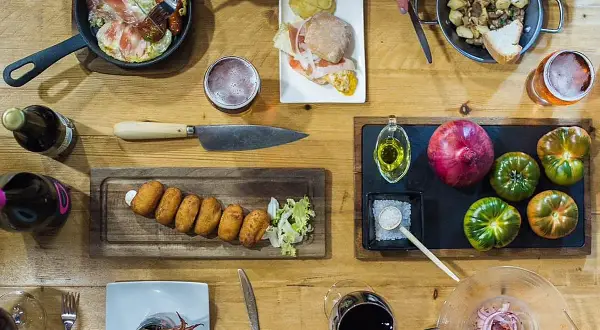 Una mesa llena de delicias para una ruta tapas: croquetas, montadito, huevo con jamón, patatas y calamares. ¡Buen provecho!