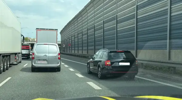 Korek na autostradzie, samochody i ciężarówki stoją w rzędzie. Kierowcy powinni pamiętać o jazda na suwak przepisy, by płynnie włączyć się do ruchu.