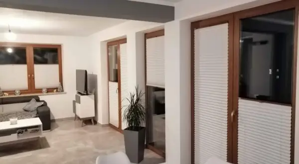 Nowoczesne wnętrze z zasłonami plisowanymi, które idealnie jak zasłonić okno. Eleganckie rozwiązanie dla każdego domu.