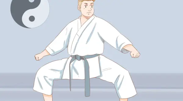 Chłopiec w białym karate gi, z szarym pasem, w pozycji bojowej. Obok symbol Yin i Yang. Poznaj nazwy sztuk walki.