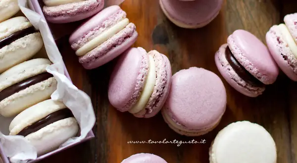 Deliziosi macarons viola e bianchi con ripieno di ganache al cioccolato e crema.