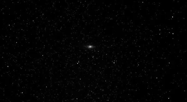 Mglista smuga galaktyki Andromeda na tle gwiezdnego nieba.