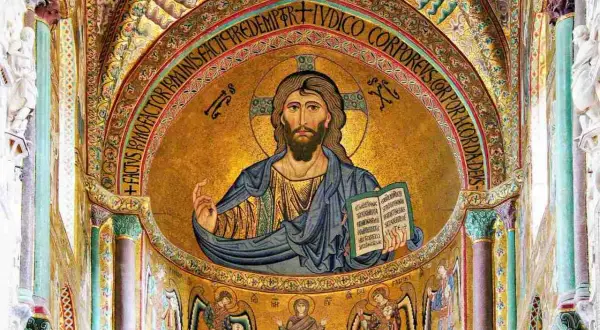 Cristo Pantocratore di Cefalù, un mosaico dorato che domina l'abside, con iscrizione latina e angeli ai lati.