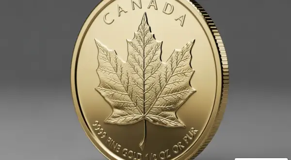 Złota moneta z wytłoczonym kanadyjskim liściem klonowym i napisem "CANADA".