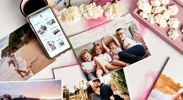 Telefon z aplikacją do zamawiania fotoproduktów, zdjęcia rodzinne, kubek kawy i bezy. Sprawdź, ile kosztuje wywołanie zdjęcia!