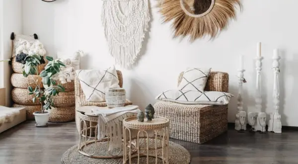 Przytulne wnętrze w stylu scandi boho: wiklinowe meble, makrama, poduszki z geometrycznymi wzorami i rośliny tworzą relaksującą atmosferę.