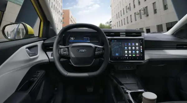 Vue du **ford puma interieur** moderne avec écran tactile, volant multifonction et tableau de bord numérique. La ville s'affiche à travers le pare-brise.