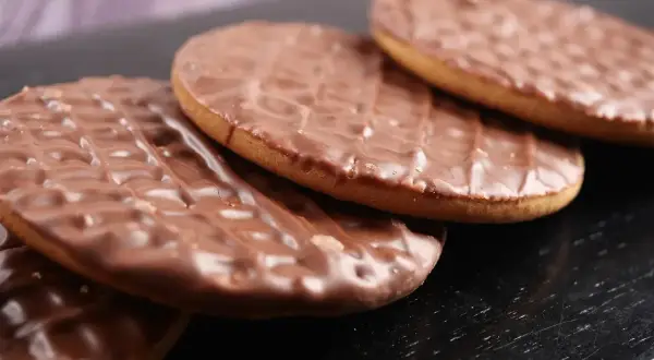 Czekoladowe ciastka digestive ułożone na czarnym tle. Idealne na popołudniową herbatę.