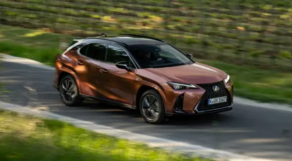 Miedziany Lexus UX na krętej drodze, idealny do miasta. Sprawdź nasze lexus ux opinie!