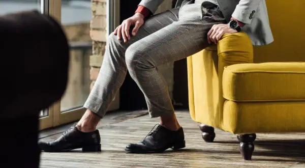 Eleganckie, brązowe oksfordy idealnie pasują do szarego garnituru w kratę. Stylowa propozycja na co dzień i od święta.