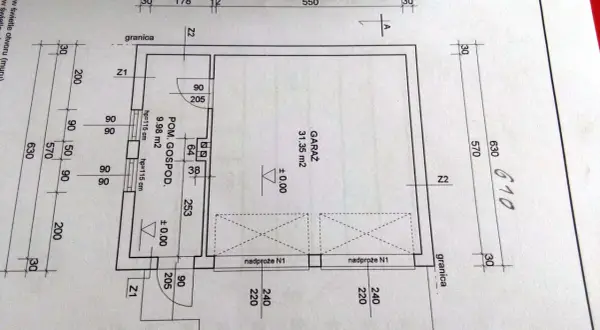 Rysunek techniczny z wymiarami garażu i pomieszczenia gospodarczego. Wymiary bramy garażowej są kluczowe dla jej dopasowania.