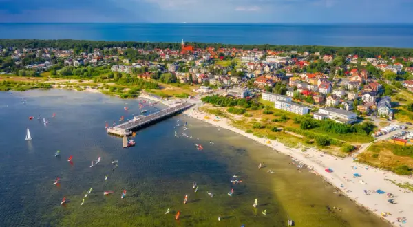 Jastarnia atrakcje: wiatr, deski i słońce na Zatoce Puckiej. Widok na molo, plażę i miasteczko.