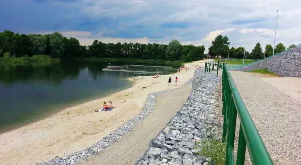 Żwirownia międzyrzec podlaski: piaszczysta plaża, kąpielisko z pomostami, ludzie odpoczywający nad wodą, zielone drzewa w tle.