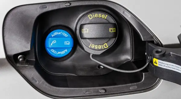 En blå AdBlue-behållare bredvid dieselpåfyllningen. För att veta hur mycket AdBlue man ska fylla på, kolla bilens instruktionsbok.