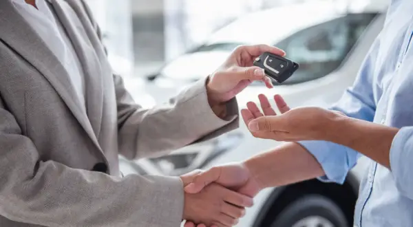 Przekazanie kluczyków do auta to ważny etap, jak przygotować auto do sprzedaży. Uściski dłoni i nowy właściciel.