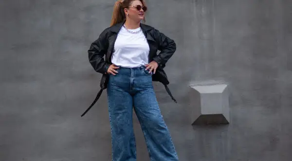 Kobieta w skórzanej kurtce i jeansach z wysokim stanem, idealnych dla puszystych. Stylowy look na co dzień.