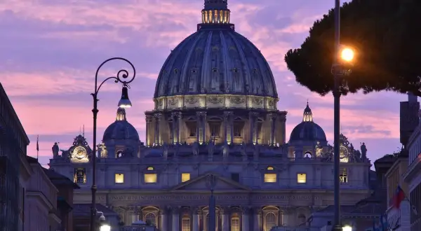 Bazylika św. Piotra o zmierzchu. W tle różowe niebo, które może symbolizować przyczyny trudności z akceptacją dogmatu o nieomylności papieża.