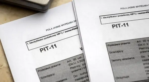 Dokumenty PIT-11 leżą obok kalkulatora. Jak rozliczyć PIT-11? To pytanie zadaje sobie wielu podatników.