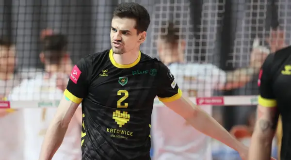 Szymański siatkarz w czarnej koszulce z numerem 2, zdeterminowany na boisku.