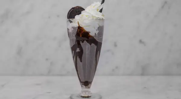 En krämig oreo milkshake med vispgrädde, chokladsås och en hel oreokaka. Perfekt för en fika!