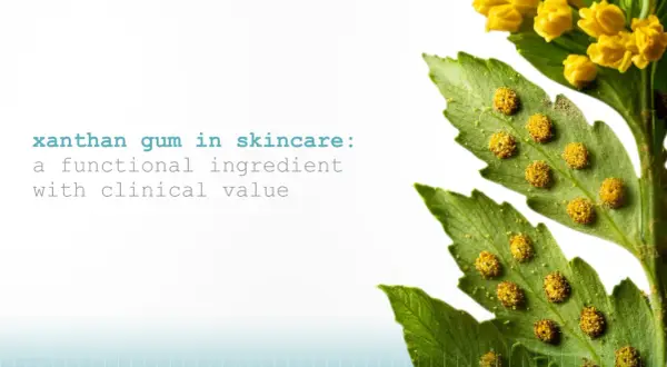 Xanthan Gum in Kosmetik: Ein funktioneller Inhaltsstoff mit klinischem Wert, dargestellt durch eine grüne Pflanze mit gelben Blüten und Sporen.