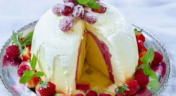 En magnifik elle nyårsdessert, en kupol av glass med lager av frukt och bär, dekorerad med färska jordgubbar och hallon.
