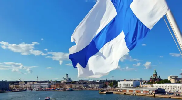 Flaga Finlandii powiewa nad portem w Helsinkach. W tle widać katedrę. Finlandia używa euro, więc to jest waluta, jaką ma Finlandia.