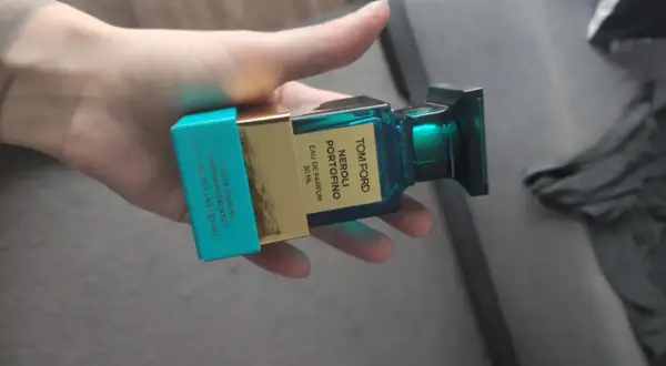 Dłoń trzyma buteleczkę perfum Tom Ford Neroli Portofino.