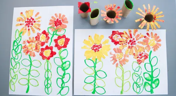 Barnens pyssel blommor med färgglada stämplar av toarullar.
