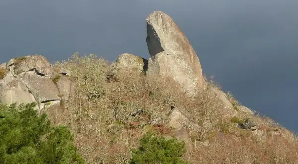 Impresionante pena corneira, una roca gigante que se alza sobre un bosque otoñal.