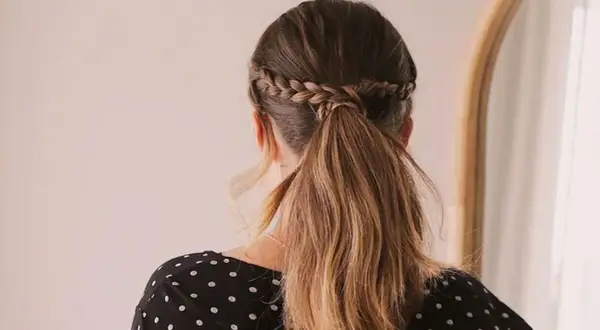 Peinados romería: coleta baja con trenza diadema, ideal para un día de campo o celebración.