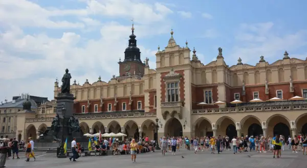 Der Marktplatz in Krakau, ein lebendiges Zentrum nach einer Reise von Breslau. Menschen flanieren vor der historischen Tuchhallen-Architektur.