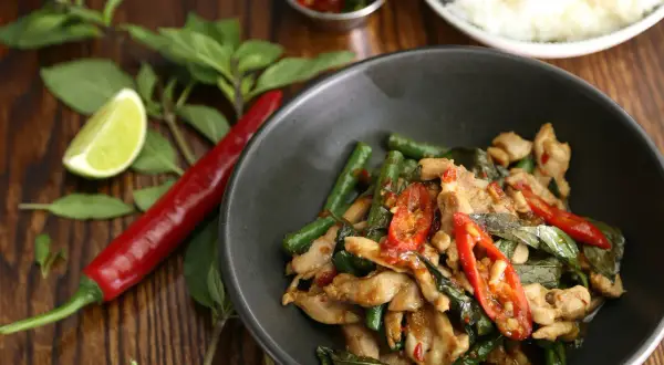 Kurczak z fasolką szparagową i chili, jedno z najpopularniejszych dań kuchni tajskiej, podany z ryżem.