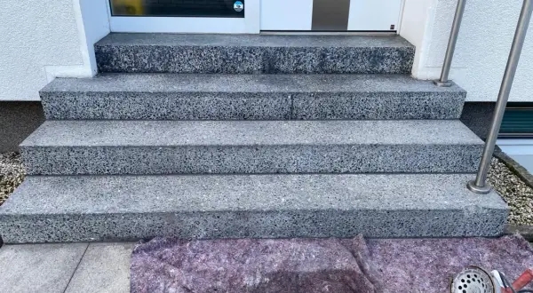 Schritt für Schritt wird die Marmortreppe gereinigt. Ein Schutzvlies liegt bereit, Werkzeug für die Reinigung ist zu sehen.