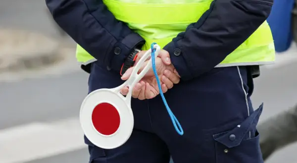 Policjant z tarczą stop. Uważaj na drogach, bo punkty karne 2025 mogą Cię zaskoczyć.